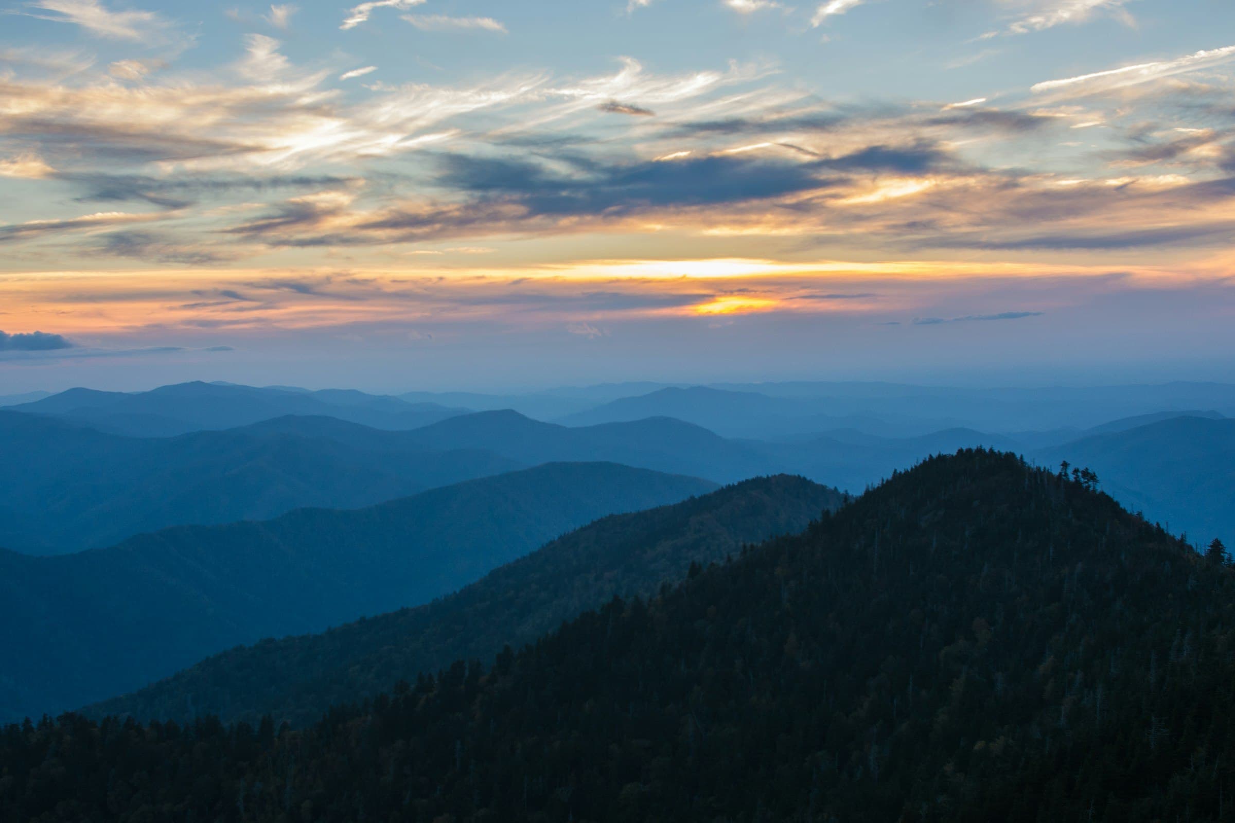 Layered Great Smoky Mountains ridgelines beneath a golden evening sky.